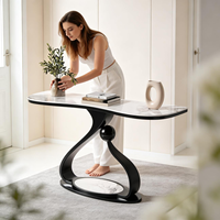 Table d'entrée de luxe de forme irrégulière avec structure en métal noir et plateau en pierre frittée pour la décoration du salon à la maison, table console