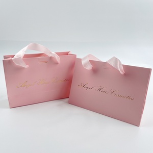 ถุงของขวัญช้อปปิ้งพิมพ์ลายโลโก้สีทองแบบกำหนดเอง ผลิตจากกระดาษเคลือบอย่างดี ปั๊มร้อน พร้อมหูหิ้วแบบยาวสำหรับเสื้อผ้าและเครื่องประดับ สีชมพู - Product Image 1