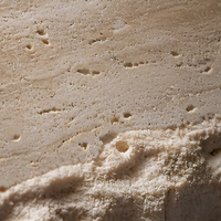 Table à manger ronde en travertin beige, base en pierre massif conique, table en travertin naturel de luxe pour la salle à manger d'une maison moderne ou d'une villa