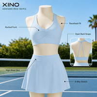 Ensemble de sport 2 pièces uni pour femme, avec brassière de sport dos nageur froncée à l'avant et jupe-short fluide taille haute avec short intégré, extensible dans quatre directions