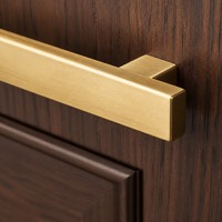 Meubles de cuisine de luxe discret noir mat, poignées or brossé, plan de travail en marbre noir, armoires modulaires à fermeture douce