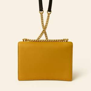 Le sac à main en cuir 2025 présente un design rectangulaire chic avec une combinaison de couleurs frappante d'or et de noir. - Product Image 2