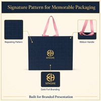 Sac de shopping bleu marine personnalisé avec poignées en ruban de satin rose, motif géométrique et logo de marque pour l'emballage de vente au détail en boutique