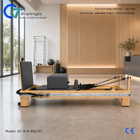 Reformer Pilates pleine longueur en bois de chêne gris anthracite avec barre de repose-pieds réglable pour studios commerciaux modernes