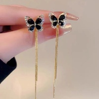Une paire de boucles d'oreilles à pampilles en forme de papillon serties de diamants super féériques avec un design élégant et rétro, un accessoire d'oreille polyvalent