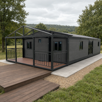 Maison conteneur pliable extensible avec cadre en acier gris anthracite, véranda et balustrade pour le glamping et la vie en plein air