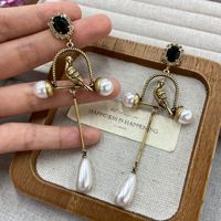 Boucles d'oreilles rétro exagérées en forme de cage à oiseaux dorée avec perles