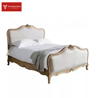 Lit double de luxe de style américain en bois massif, finition bois ciré blanc, avec tête de lit rembourrée en osier et motifs sculptés à la française