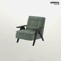 Fauteuil NORYA écologique et contemporain en tissu vert, avec larges accoudoirs en bois, dossier haut et assise rembourrée, idéal pour salon, chambre et lecture