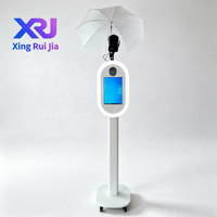Xingruijia XRJ-cmp Photomaton ovale en métal à impression instantanée, écran tactile 14 pouces, appareil photo, impression en libre-service, ventilateurs de refroidissement RGB, détachable