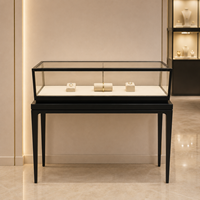 Vitrine à bijoux autoportante en verre avec cadre noir, pieds hauts et éclairage LED pour les bijouteries professionnelles