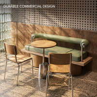 Ensemble de bancs vert sauge avec coussins et traverses, table ronde en bois avec chaises et tables sur piédestal pour restaurant, idéal pour café peu encombré