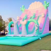 Toboggan aquatique gonflable Monde sous-marin, design dauphin et poisson, avec grande piscine, couleurs pastel, combo toboggan et trampoline pour fête