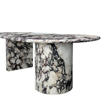 Table à manger asymétrique à double piétement, en marbre massif, avec dalle ovale organique et veinage noir sauvage entrelacé, style minimaliste