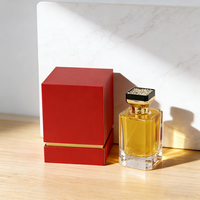 Parfum élégant dans un flacon carré transparent à côté d'une élégante boîte cadeau noire