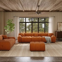 Ensemble de canapés modulaires capitonnés en velours orange, style mid-century, avec sièges profonds et accoudoirs incurvés surdimensionnés pour le salon
