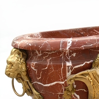 Baignoire autoportante ovale en marbre rouge avec veines blanches, pieds sculptés en forme de sirène et tête de lion dorée, luxe pour hôtel