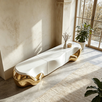 Meuble TV sculpté en or métallique fluide avec cadre en fibre de verre blanc brillant, à poser au sol, pour un intérieur de maison moderne et luxueux