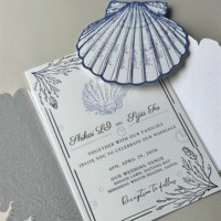 Invitation de mariage haut de gamme imprimée en offset avec motif coquillage et branche en relief sur papier offset