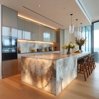 Cuisine moderne de luxe modulaire avec finition laquée, îlot de cuisine éclairé, plan de travail en marbre, évier et crédence