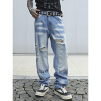 Jeans en denim délavé bleu clair sur mesure pour homme, coupe oversize ample à jambe large, détails déchirés prononcés, hiver