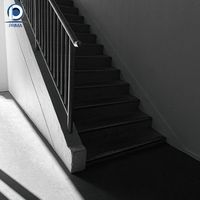 Escalier en L vintage personnalisé Prima en pierre noire avec main courante en bois foncé et balustres en fer ornés de laiton pour manoir classique