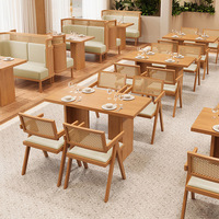 Table à manger en bois blond, chaise avec dossier en cannage tressé, siège rembourré blanc, banquette couleur sauge pour restaurant et hôtel