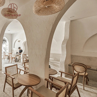 Ensemble de mobilier de restaurant au design naturel moderne : chaises en bois à dossier croisé, table ronde en marbre, banquette en tissu pour usage commercial