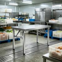Table de travail pliante industrielle avec surface en acier inoxydable et pieds articulés pour cuisines commerciales, zones d'assemblage, d'emballage et de service