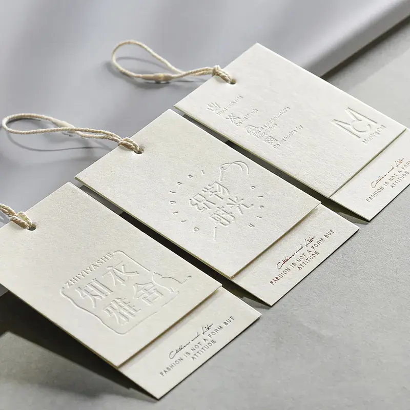Étiquette volante en carton de luxe personnalisée pour vêtements Étiquettes de balançoire en papier texturé avec relief pour jeans