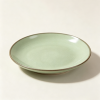 Collection de vaisselle en poterie verte rustique élégante EKA, assiettes et bols en céramique au look artisanal avec bord infusé de fer