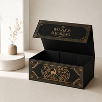 Caja Rígida Magnética Plegable con Superficie Negra Adornada con Logotipo en Lámina Dorada y Patrón Ornamentado en el Interior
