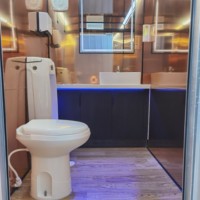 Remorque de toilettes mobiles à trois postes, aspect bois hybride, avec plans de travail double vasque, pour villages de glamping de luxe