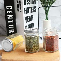 Vente en gros de petits, moyens et grands pots hexagonaux en verre avec couvercles en plastique et en aluminium pour le stockage de bonbons, dessert et confiture de miel