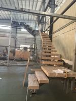 Escalier flottant sur mesure avec design à montantes fermées, poutre de support entièrement dissimulée, garde-corps en verre trempé et marches en bois