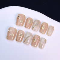 Ongles press-on faits main, nude effet œil de chat, fleurs dorées en relief, strass, ongles courts carrés délicats