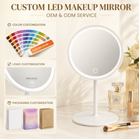 Miroir LED à éclairage latéral avec surface ronde transparente, bouton tactile et base ovale discrète pour une application de maquillage détaillée