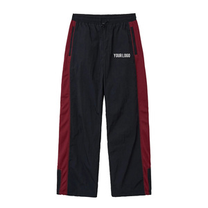 Pantalon de survêtement noir pour homme à taille élastique avec bande latérale rouge, cordon de serrage réglable, logo personnalisé sur la jambe droite, coupe décontractée ample - Product Image 1