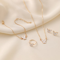 Juego de Joyería de 4 Piezas con Mariposa de la Suerte para Mujer, Dije Esmaltado en Blanco y Rosa, Pulsera, Gargantilla, Collar, Anillo y Aretes Bañados en Oro