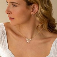 Collier de luxe en cuivre avec nœud papillon et perles d'imitation, design unique, sensation haut de gamme, tendance et polyvalent pour femme