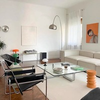 Un bureau à domicile avec une table basse carrée moderne et des meubles de salon transparents avec verre trempé et cadres métalliques