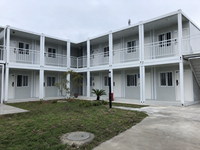 Maison préfabriquée modulaire à double niveau en panneaux d'acier à assembler, avec garde-corps en L, design moderne extérieur, 60 pieds, garantie 5 ans