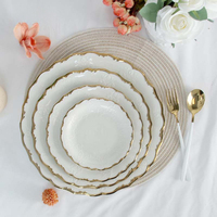 Ensemble d'assiettes et de bols en porcelaine élégants à bords dorés, design festonné, vaisselle en céramique pour repas raffinés