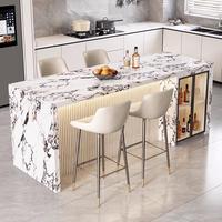 Îlot de cuisine en pierre frittée veinée de marbre blanc, panneau cannelé en bois, éclairage LED d'ambiance, évier et charnières pour cuisine et salle à manger modernes