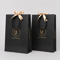 Sac cadeau en papier noir mat avec logo personnalisé imprimé en feuille d'or, sac en carton de luxe avec poignée torsadée pour l'emballage de cosmétiques et de maquillage