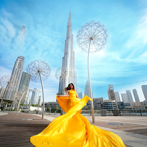 ผู้หญิงสวมชุดเดรสสีเหลืองสดใสสง่างาม กำลังถ่ายภาพหน้าตึกสูง บูร์จ คาลิฟา ที่เป็นที่นิยมในใจชาวโลก - Product Image 1