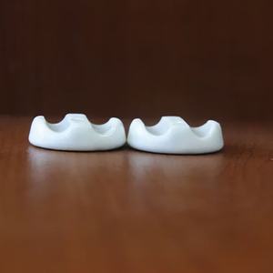 Fermacavi doppio in porcellana bianca 31x18mm, ideale per l'organizzazione dei cavi e il mantenimento di spazi ordinati. - Product Image 1