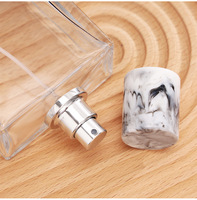 Flacon pulvérisateur d'huile de parfum en verre transparent carré de 50 ml, col serti de 15 mm, atomiseur de parfum, bouchon en marbre noir mat, logo personnalisé