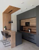 Comptoirs en quartz/marbre artificiel/stratifié, armoires de cuisine modernes avec appareils électroménagers intégrés, évier et robinet.