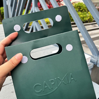 Sac cadeau en papier mat laminé vert foncé avec logo en relief découpé et couvercle plat, fourni par le fabricant